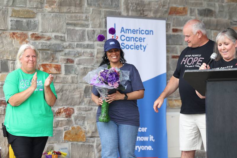 Michelle Pruitt, American Cancer Society staff partner, is recognized by event chair Michelle Sadler, left, and honorary chairs Mike and Areca Van Mill, right, during the opening ceremony for the Relay for Life of Kankakee County on June 14, 2025, at The Grove in Bourbonnais. Pruitt was recently recognized by the Illinois Board of Trustees for the American Cancer Society for 18 years of service.