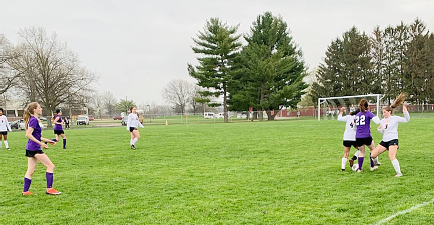 Dixon's Sydney Chesley (22) battles for the ball with DeKalb's Laura Ovalle-Cruz and Isabella Schmerbach (4) on Thursday, May 5, 2022.