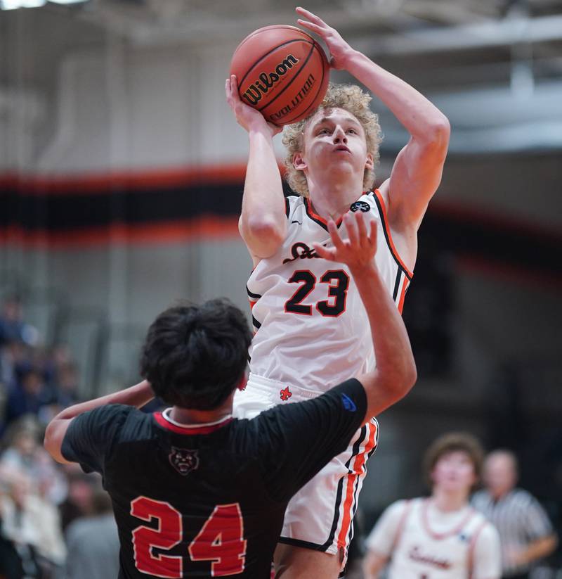 St. Charles East's Matt Steinberg (23) shoots the ball in the paint over East Aurora's Luis Umana (24) during the 64th annual Ron Johnson Thanksgiving Basketball Tournament at St. Charles East High School on Monday, Nov 20, 2023.