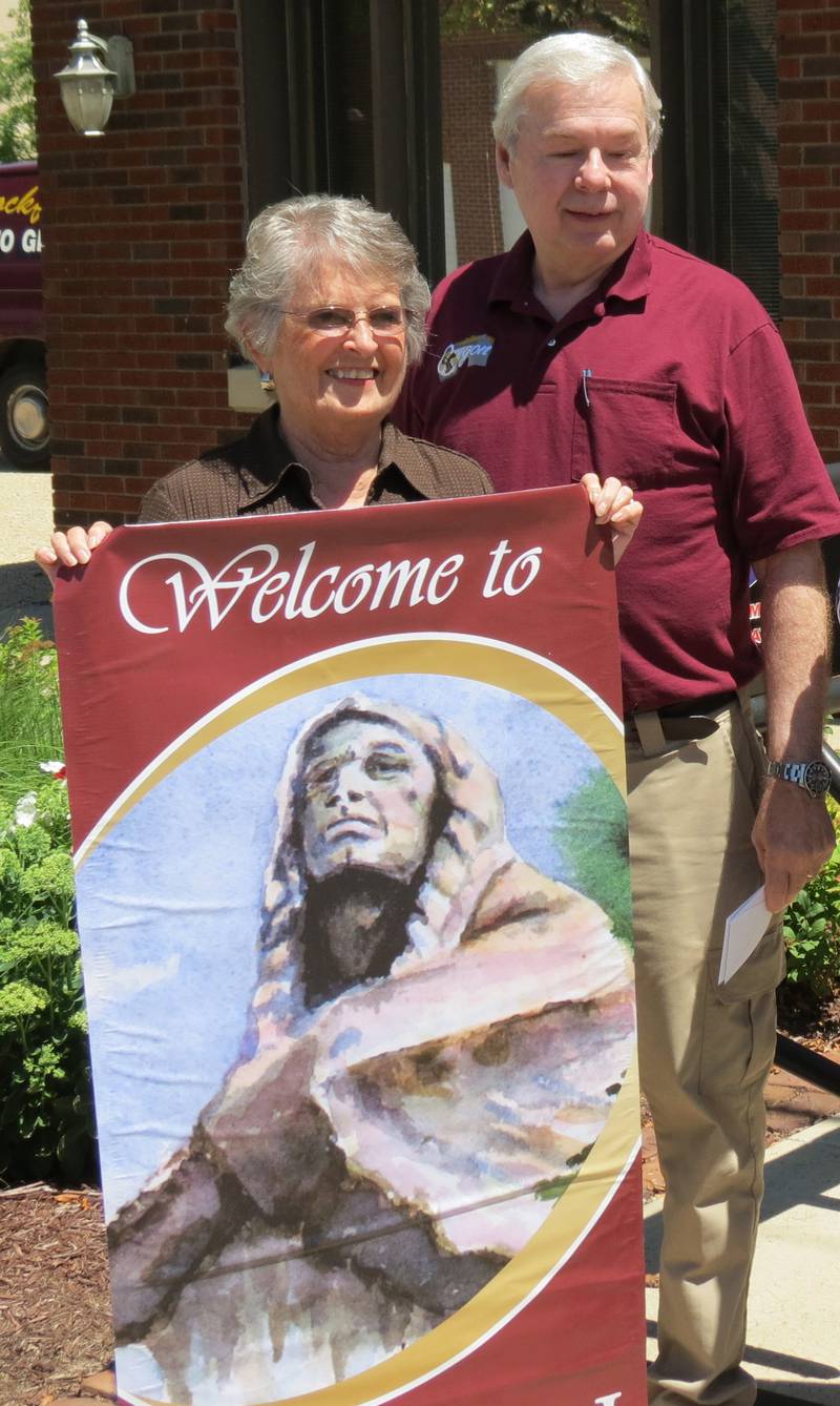 The late Jan Harvey (left) and Oregon Mayor Ken Williams stand by one of the flags Harvey designed while she was a member of the Eagle's Nest Art Group.