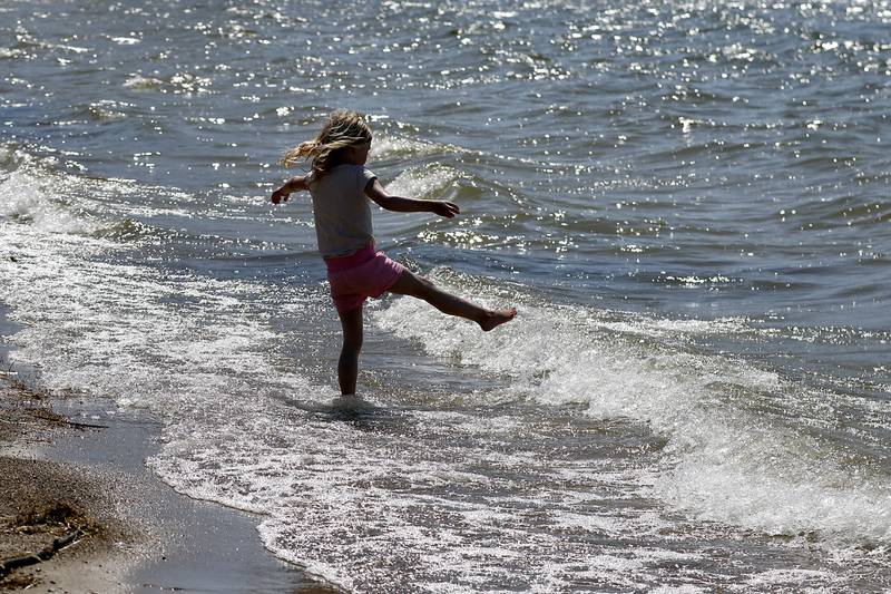 Mila Keller, 5, of Crystal Lake plays in the water Wednesday, April 12, 2023, as she enjoys an unseasonable warm day at Crystal Lake’s Main Beach.