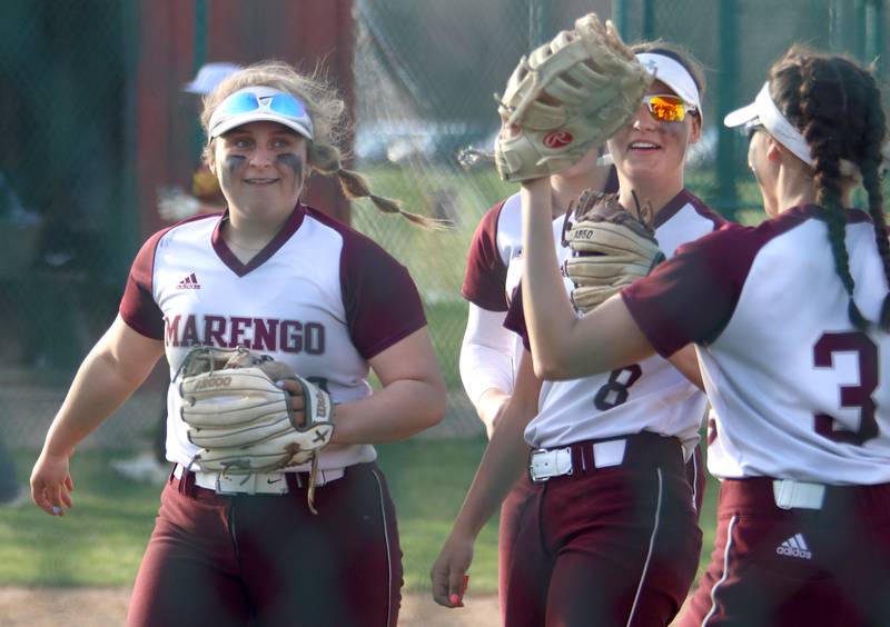 Marengo’s Emily White, left, is greeted by teammates after initiating a double play against Richmond-Burton in varsity softball at Marengo Tuesday.