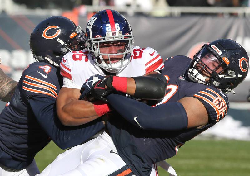 Chicago Bears free safety Eddie Jackson and outside linebacker Trevis Gipson bring down New York Giants running back Saquon Barkley during their game Sunday, Jan. 2, 2021, at Soldier Field in Chicago.