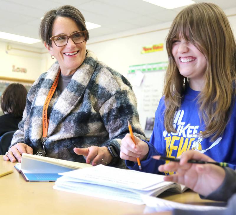 Mary Lynn Buckner, longtime educator at Littlejohn Elementary School, has a laugh with a student as she supports Nicole Schmidt's fifth-grade class during their individual work time Tuesday, March 14, 2023, at the school in DeKalb.