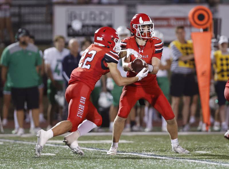 Hinsdale Central's Riley Contreras (1) hands off to Dominic Tressler (22) during the varsity football game between York and Hinsdale Central on Friday, Oct. 3, 2025 in Hinsdale, IL.