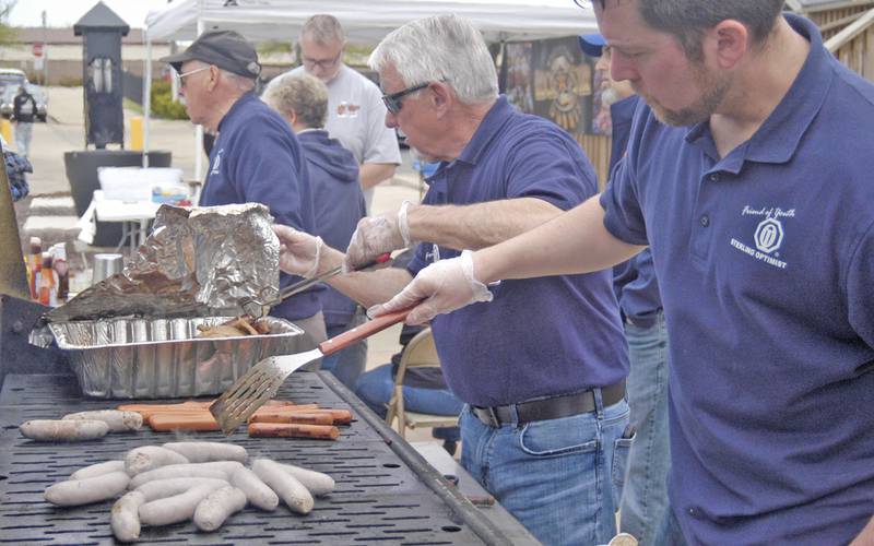 Sterling Optimists Steve Mosel and Brian Marchand cook up dogs and brats during the car show.Sterling Main Street's 12th Annual Car Show took place at the Sterling Marketplace on Sunday, May 4th, 2025.