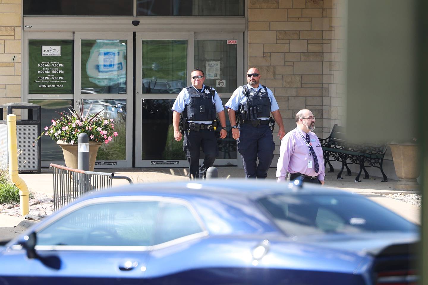 Several police officers leave the Black Road Branch Library after a bomb  threat at that location on Thursday, Sept. 14, in Joliet.