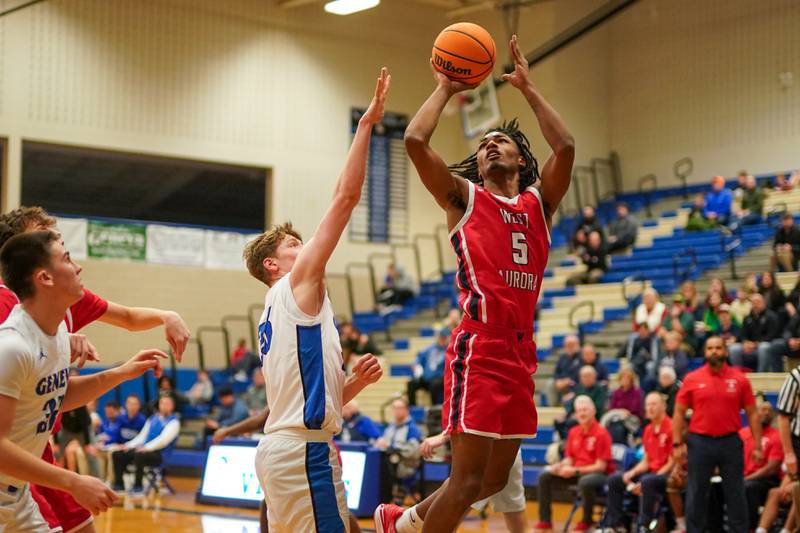 West Aurora's Terrence Smith (5) shoots the ball in the post  over Geneva’s Hudson Kirby (25) during a MLK Day of Hoops basketball game at Geneva High School on Monday, Jan. 20, 2025.