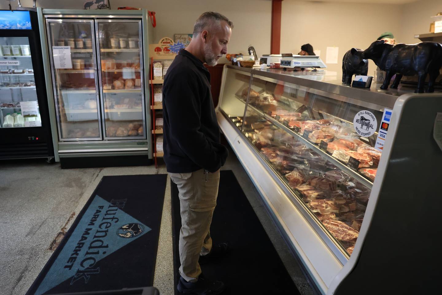 Paul Lichamer looks over the fresh cut meats while his order is put together at Hufendick Farm Market in Downtown Plainfield on Tuesday, February 21st, 2023.