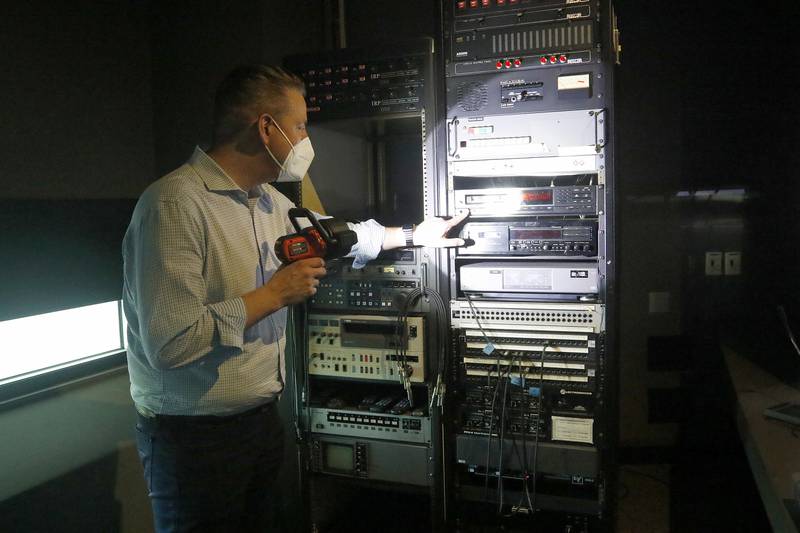 Green Data Center Real Estate Inc. CEO Jason Bak shows the multi-cd disc changers located inside the projection room of the theater inside the property at the former Motorola headquarters on Thursday, June 10, 2021 in Harvard.