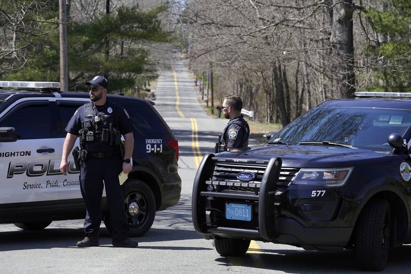 Members of Dighton Police Department stand at a road block, Thursday, April 13, 2023, in Dighton, Mass., about one half a mile from where FBI agents converged on the home of a Massachusetts Air National Guard member who has emerged as a main person of interest in the disclosure of highly classified military documents on the Ukraine. The guardsman was identified as 21-year-old Jack Teixeira. (AP Photo/Steven Senne)