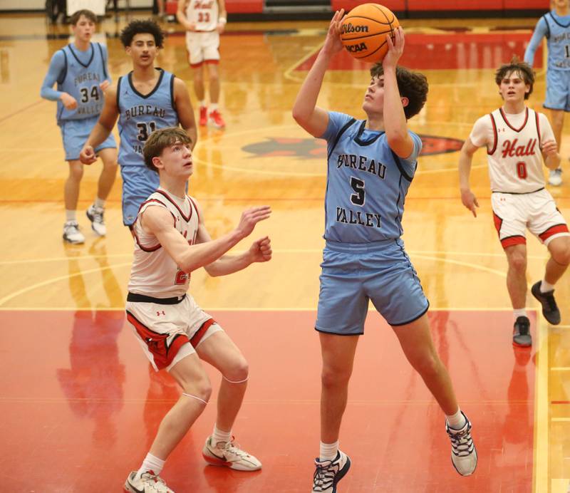 Bureau Valley's Logan Philhower lets go of a shot in the lane over Hall's Gage Olson on Wednesday, Jan. 28, 2026 at Hall High School.