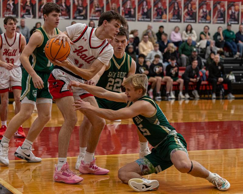 Clayton Fusinetti (21) of Hall holds ball as St. Bede's Gino Dinges (15) dives for possession on Saturday, January 31, 2026 at Hall High School in Spring Valley.
