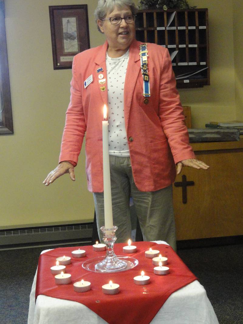 Alice Giberson lights a candle for her patriot, John Harbaugh, during the memorial service.