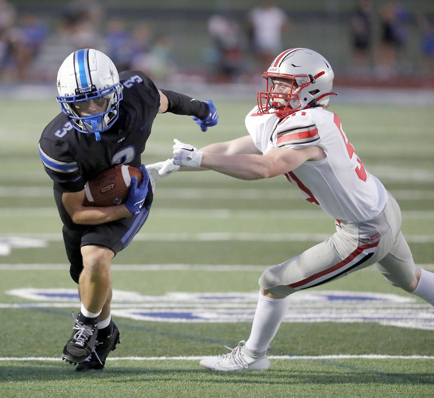St. Charles North's Jake Mettetal (3) moves around Palatine's Joe Reiswig (50) Friday August 25, 2023 in St. Charles.