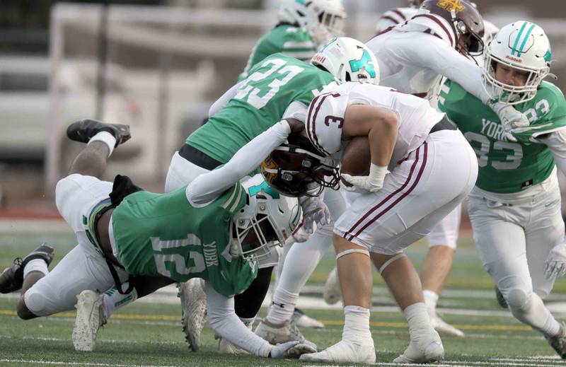 Loyola's Quinn Foley (3) is brought down by York’s Marquan Brewster (12) during the IHSA Class 8A semifinal football game Saturday November 19, 2022 in Elmhurst.