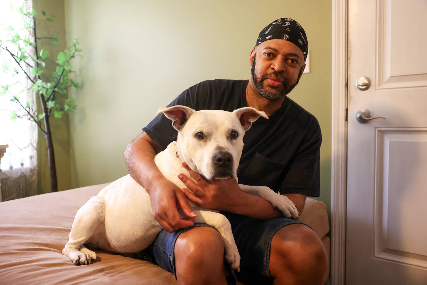 EF Ellington, of Hopkins Park, sits with his dog, Mz. CC, after recently being reunited after she had been missing for six years.