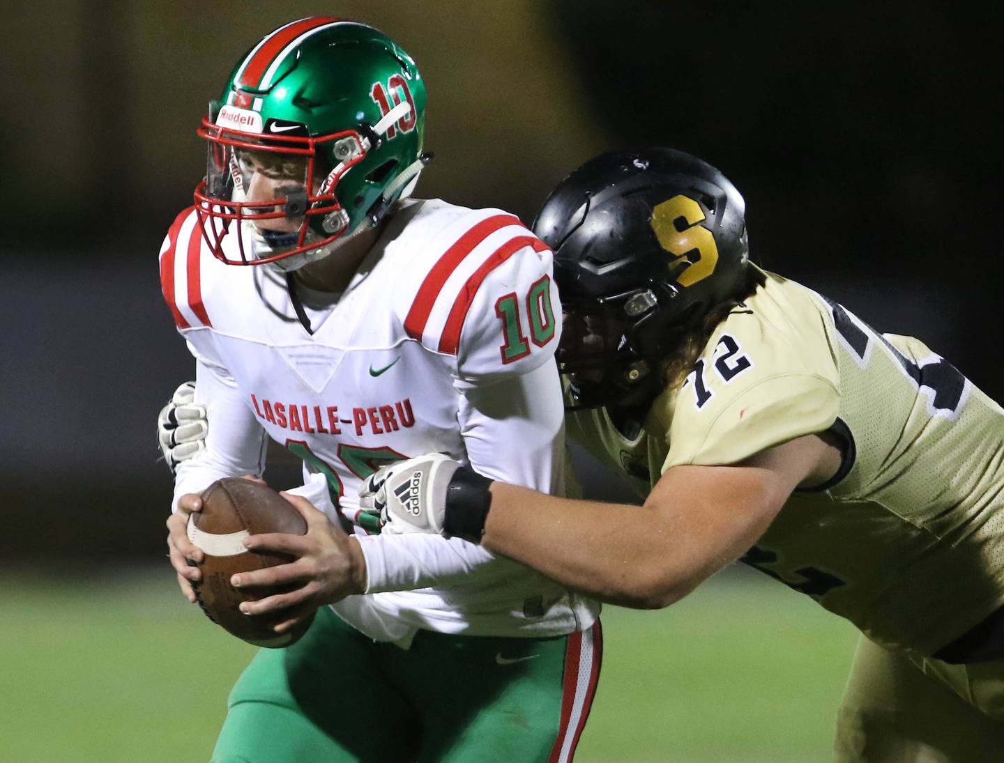 LaSalle-Peru quarterback Sean Whitfield looks to pitch the ball as Sycamore's Lincoln Cooley tries to wrap him up during their game Friday Sep. 25, 2021 at Sycamore High School.