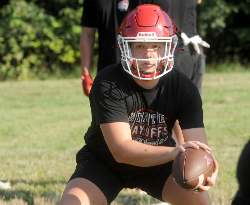 Yorkville quarterback Michael Dopart takes a snap during football practice at Yorkville High School on Tuesday, Aug 8, 2023.