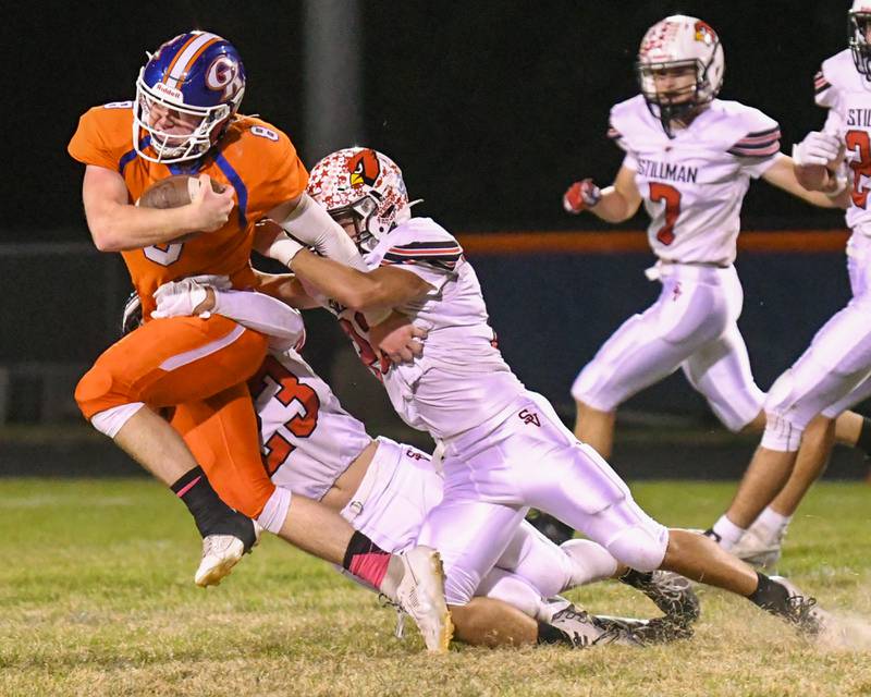 Genoa-Kingston's Nathan Kleba, left, runs the ball for a first down before being brought down by Stillman Valley Luke Miller (22) and teammate Jackson Musial (23) during the game on Friday Oct. 11, 2024, held at Genoa-Kingston high School.