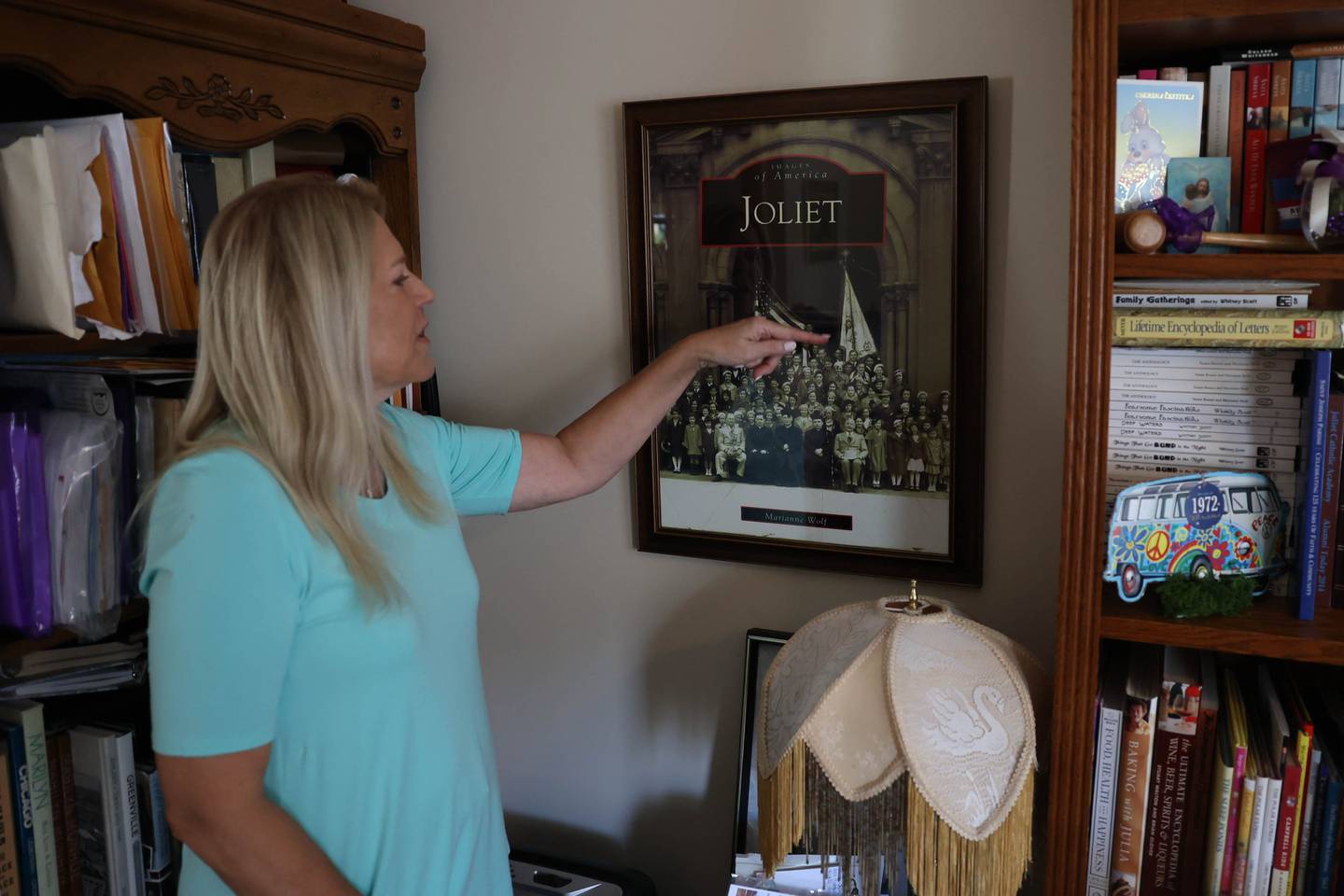Marianne Wolf-Astrauskas points to her aunts in an old photo on Tuesday, Sept. 20, 2022, in Orland Park. The photo was taken in front of the old St. Joseph Catholic Church in Joliet. She used that photo for her 2016 book on Joliet. Wolf-Astrauskas created a 70-page book for the combined 50th reunion of the former Catholic High School and St. Francis Academy.