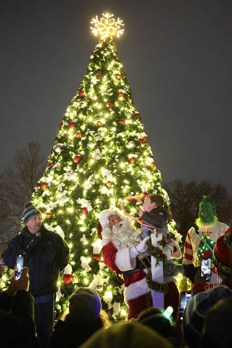 Hunter Hess, 7-years-old, and Santa light the Christmas tree at Plainfield’s holiday kickoff Grinchmas on the Green on Saturday, Dec. 5, 2025 in Plainfield.