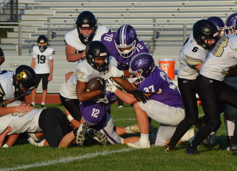 Rochelle's Andrew Eyster and Brayden Harley (78) make the tackle as Jonathan Andrist tries to strip the ball during a JV football game with Sycamore.