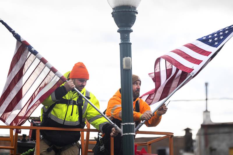 Josh Yocum (left) and Matt Lindstrom replace flags for wreaths Wednesday, Nov. 20, 2024, as the city of Dixon gears up for the holiday season.