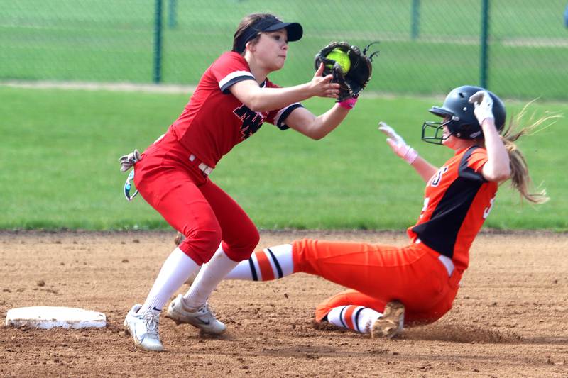 St. Charles East’s  Abby Arend, right, slides in safely with a steal at second base as Huntley’s Sadie Svendsen grabs the throw during varsity softball at Marengo Saturday morning.