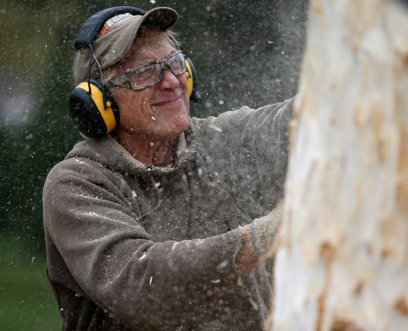 Bud Hainzinger of Morris carves a cross in a tree stump at St. Johns Lutheran Church on Friday, Nov. 3, 2023 in Peru.