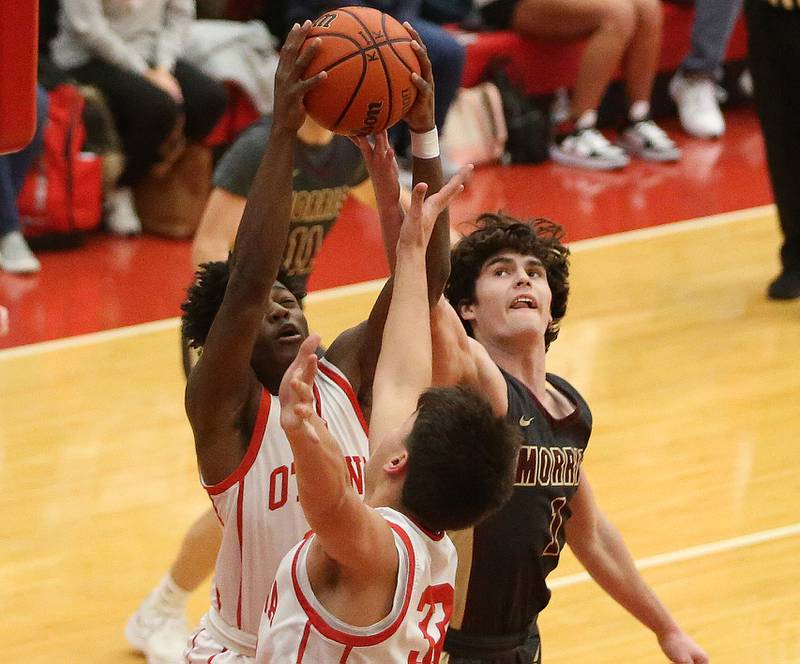 Ottawa's Keevon Peterson and teammate Cooper Knoll grab a rebound over Morris's AJ Zweeres on Wednesday, Jan. 3, 2024 at Kingman Gym.