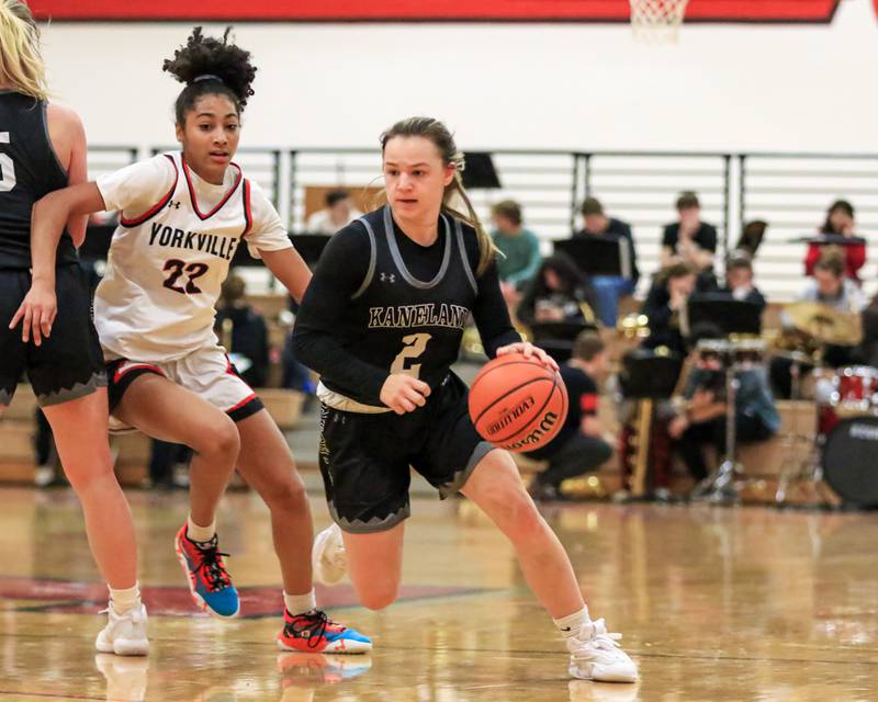 Kaneland's Kailey Plank (2) takes off to the basket while Yorkville's Alex Stewart (22) is screened by Brigid Gannon (5) during varsity basketball game between Kaneland at Yorkville. Dec 14, 2022.