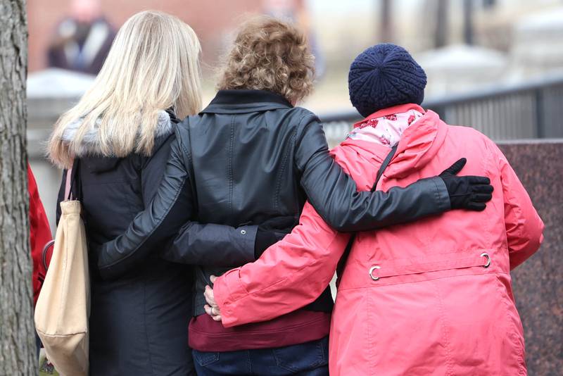 Friends and families of the victims pay their respects during a remembrance ceremony Tuesday, Feb. 14, 2023, at the memorial outside Cole Hall at Northern Illinois University for the victims of the mass shooting in 2008. Tuesday marked the 15th year since the deadly shooting took place on campus which took the lives of five people.