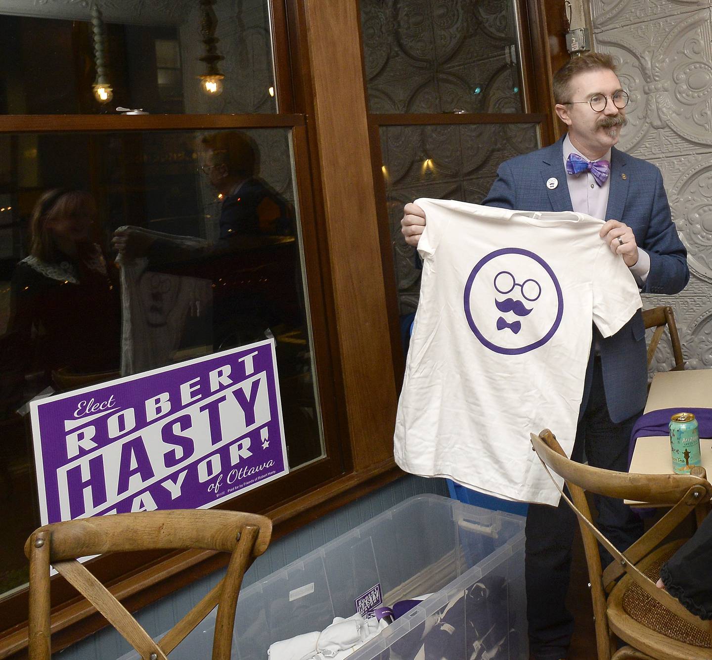 Robert Hasty shows off a t-shirt bearing a likeness to him on Tuesday, April 4, 2023 at CatsEye in Ottawa