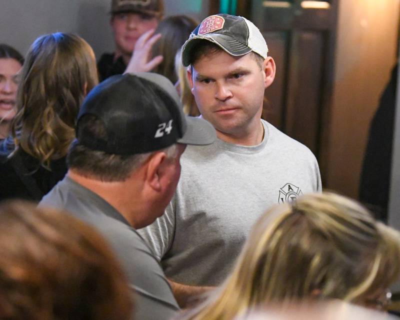 DeKalb firefighter Adam Miller talks to his dad Brett Miller, a Maple Park firefighter, on Wednesday Nov. 27, 2024, at Fatty's Pub and Grille in DeKalb during the DeKalb Fire Fighters Local 1236 union's Tip A Firefighter event to fundraise for the Muscular Dystrophy Association.