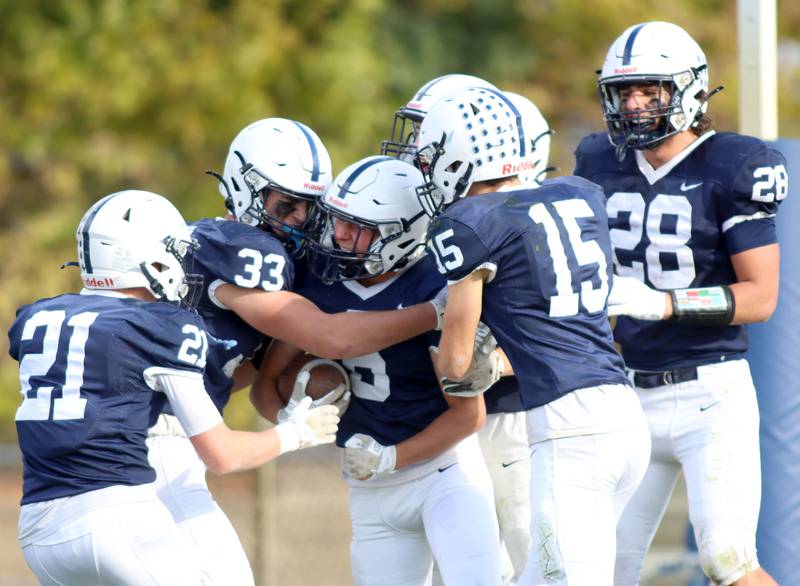 Cary-Grove’s Trojans swarm teammate Joe Pristera after a late interception against Sycamore in IHSA football Class 5A first-round playoff action at Al Bohrer Field on the campus of Cary-Grove High School in Cary on Saturday, November 1, 2025.