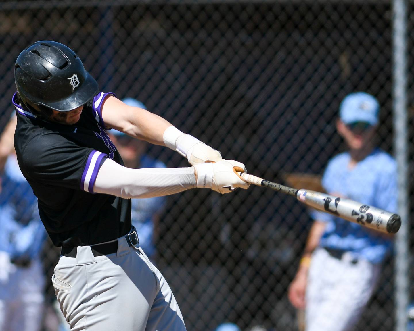 Downers Grove North’s Jimmy Janicki makes contact with the ball that went deep to right field and caught by Downers Grove South.