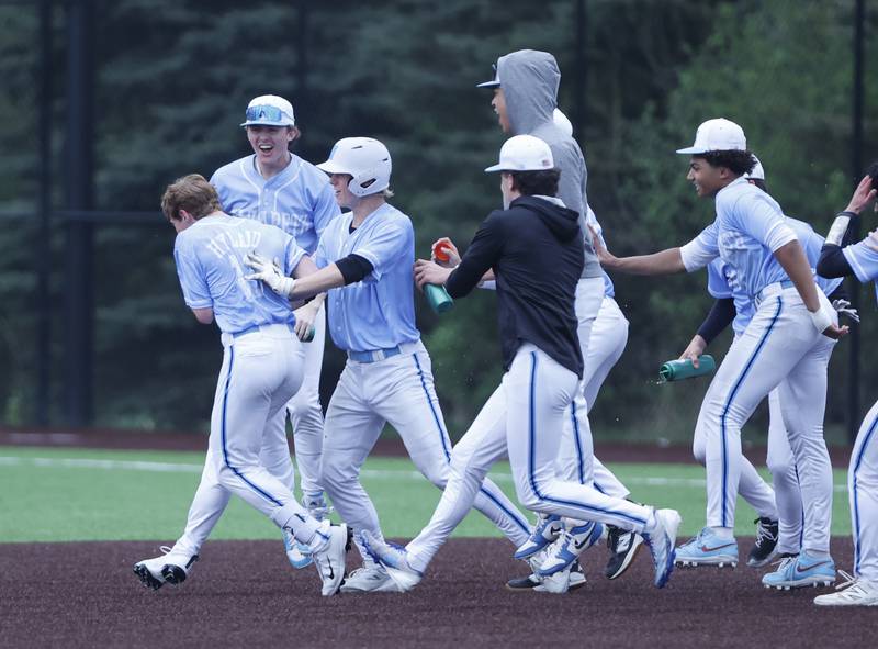 Nazareth celebrates Drew Hyland's (13) walk-off game-winning hit against Joliet Catholic during the varsity baseball game on Wednesday, April 20, 2025 between Nazareth and Joliet Catholic academies in La Grange Park.
