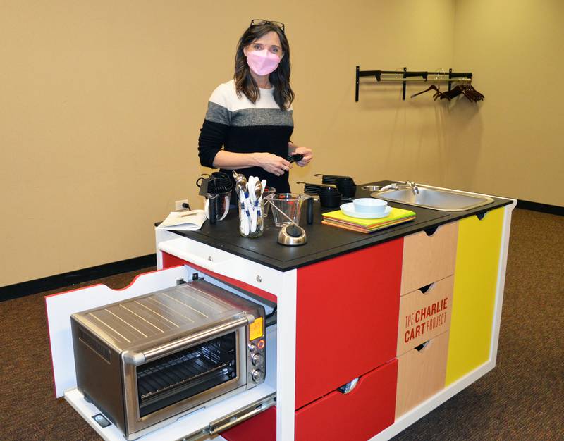La Grange Library's Public Services Coordinator Laura Goldsborough demonstrates the newly acquired mobile kitchen, dubbed a Charlie Cart, made possible by a grant.