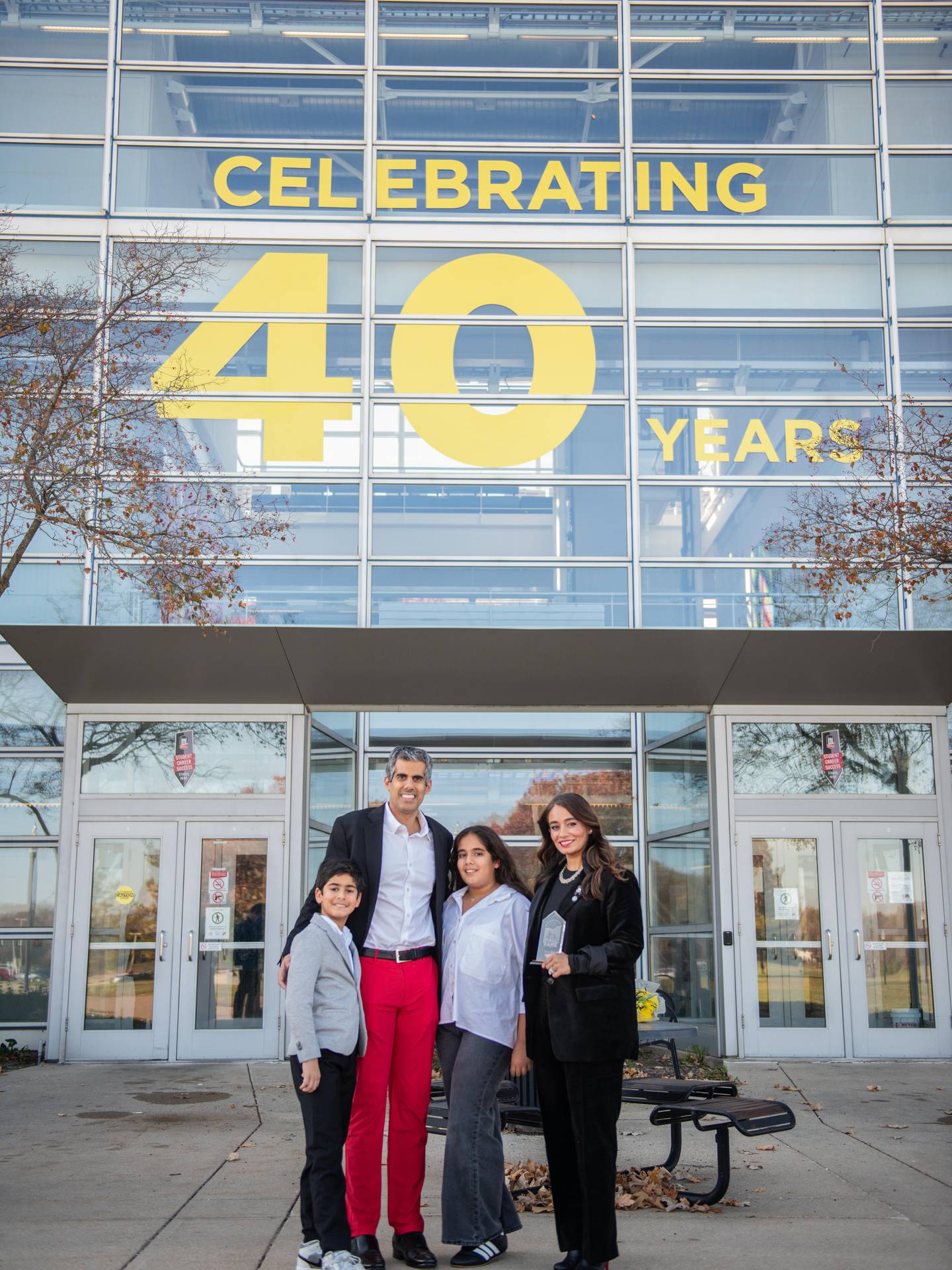 Divya Behl and her husband. Dr. A. Rishi Behl, along with their two children outside the NIU Engineering Building on Nov. 14, 2025.