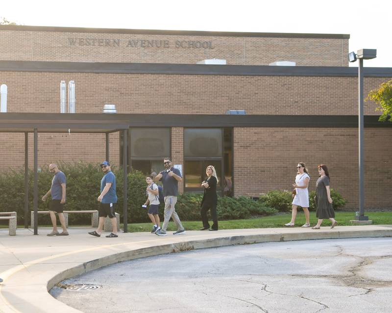Friends and family walk with their kids during the first day of school on Thursday Aug. 21, 2025, at Western Avenue Elementary School in Geneva.