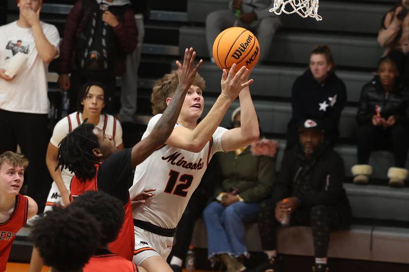 Minooka’s Zane Caves finesses a shot against Bolingbrook on Tuesday, Dec. 17, 2024 in Minooka.