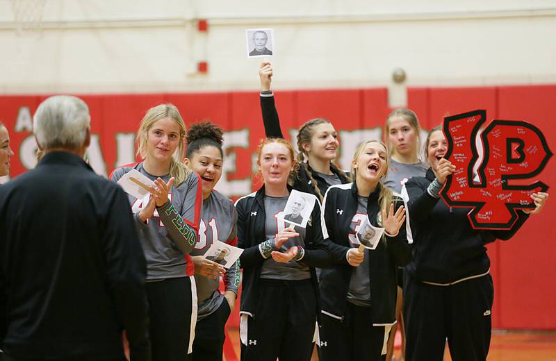 Members of the L-P volleyball team present L-P head coach Mark Haberkorn with a L-P logo signed by the team during a special celebration after getting his 1000th career win against Ottawa on Tuesday, Oct. 18, 2022 at Sellett Gymnasium at L-P.