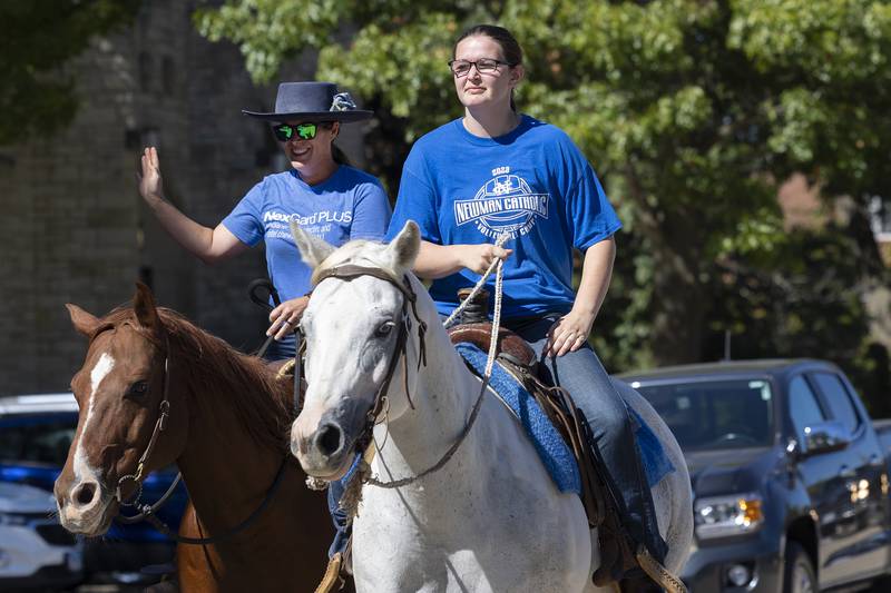 Lisa Bush (left) and Mykala Muldering ride horses Friday, Sept. 20, 2024, through Newman High School’s homecoming parade.
