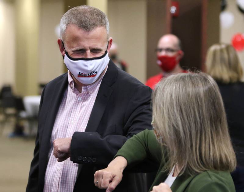 DeKalb mayoral candidate Cohen Barnes greets a supporter with an elbow bump Tuesday during an election night party at Faranda's Banquet Center in DeKalb.