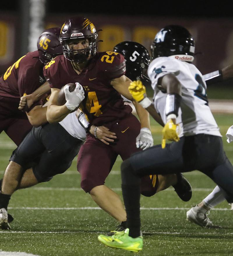 Richmond-Burton's Hunter Carley runs with the ball as Woodstock North's Sean Mitchell prepares to tackle Carley during a Kishwaukee River Conference football game on Friday, Oct. 11, 2024, at Richmond-Burton High School.