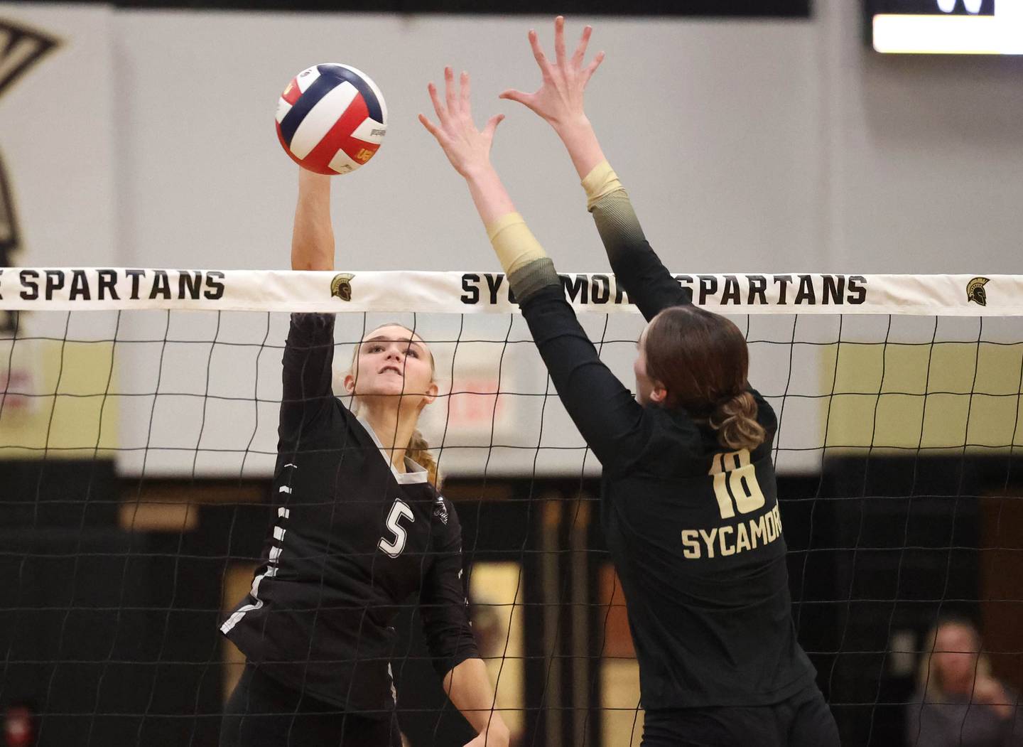 Kaneland's Kayli Loonam tries to spike the ball by Sycamore's Sophia Martinez during their match Tuesday, Oct. 1, 2024, at Sycamore High School.