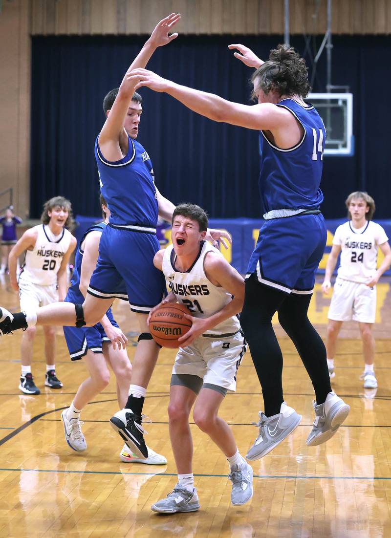 Serena's Braxton Hart gets Hinckley-Big Rock's Ben Hintzsche (left) and Martin Ledbetter up in the air with a pump fake Friday, Feb. 3, 2023, during the championship game of the Little 10 Conference Basketball Tournament at Somonauk High School.