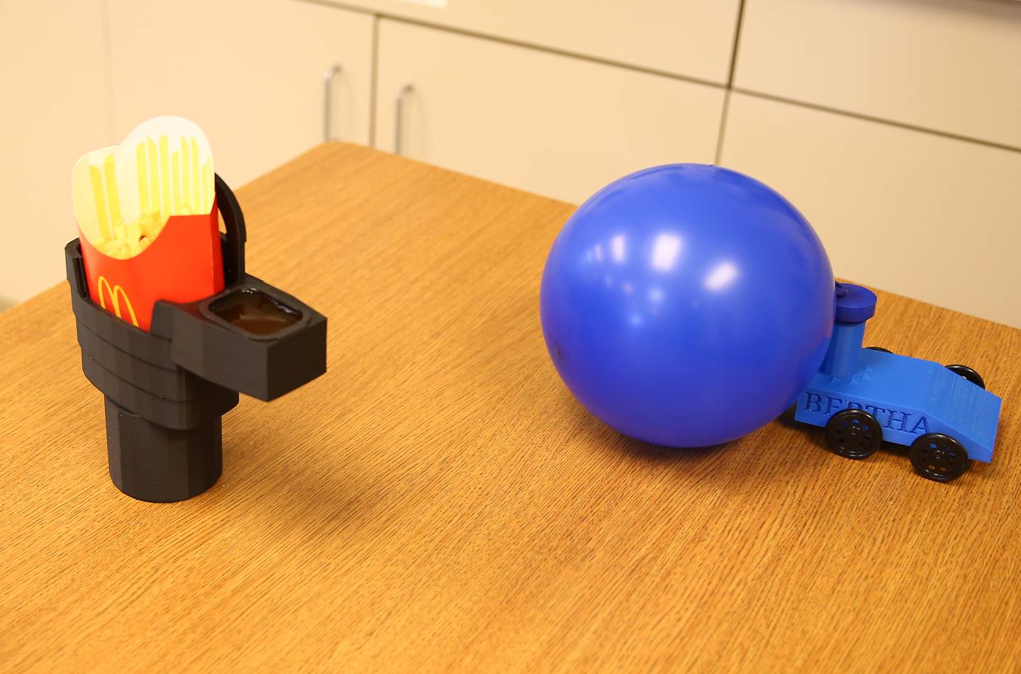 Students Joey Libhart and Brayden Brewer, created and designed these 3-D printed objects in Mrs. Kathy Ferko's STEM class at Wallace Grade School on Thursday, April 7, 2022 in Wallace.  Brewer, made a holder that rests fast food into a vehicle drink tray including condiments while Libhart, designed a car that moves attached to a balloon.
