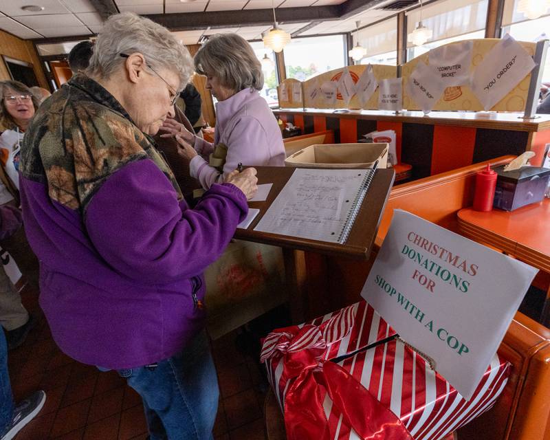 Ruth Herbst writes note for Sam Leone at Sam’s retirement celebration on Saturday, October 25, 2025 at the Rootbeer Stand in Oglesby.